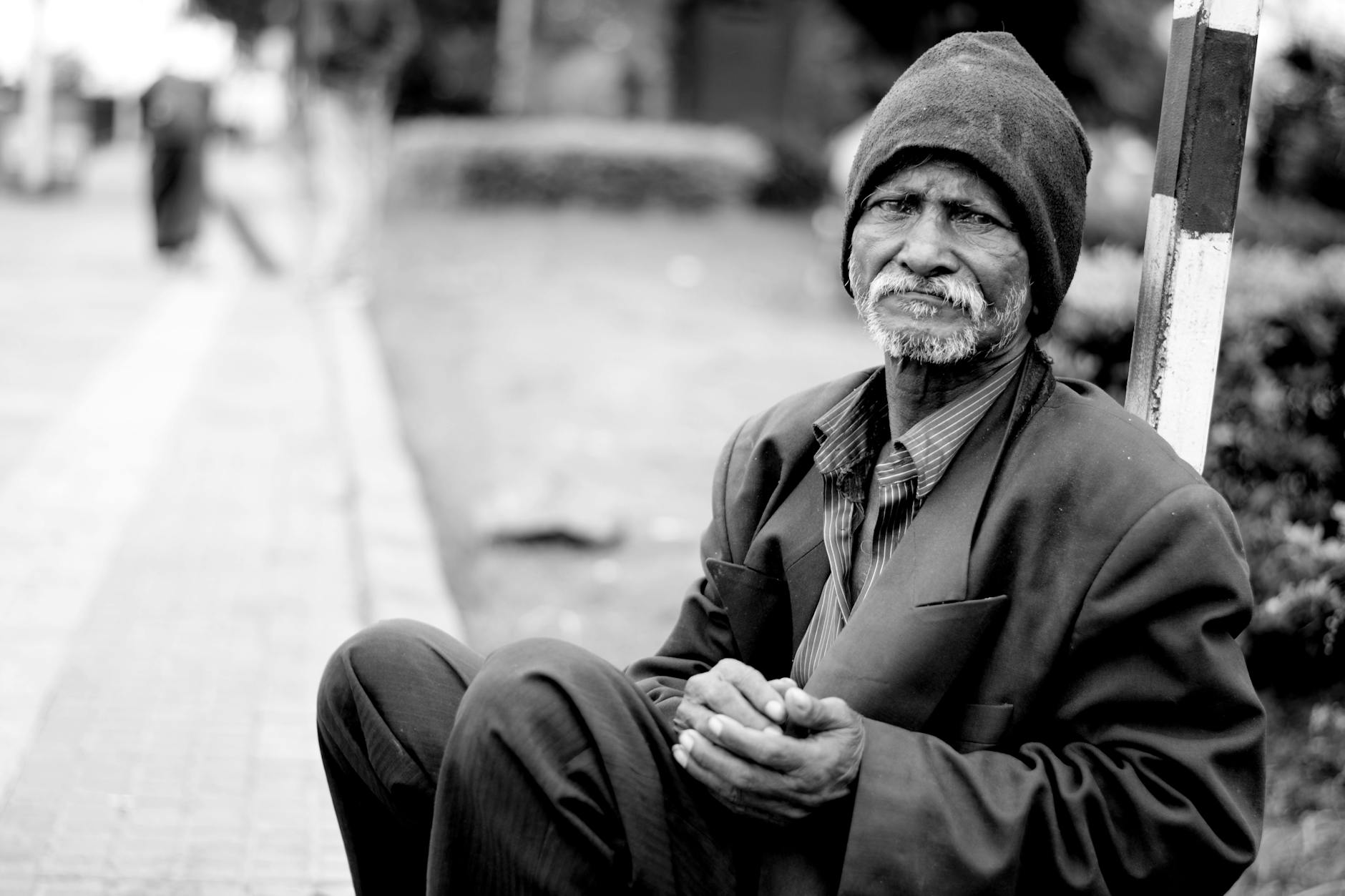 grayscale photography of man sitting