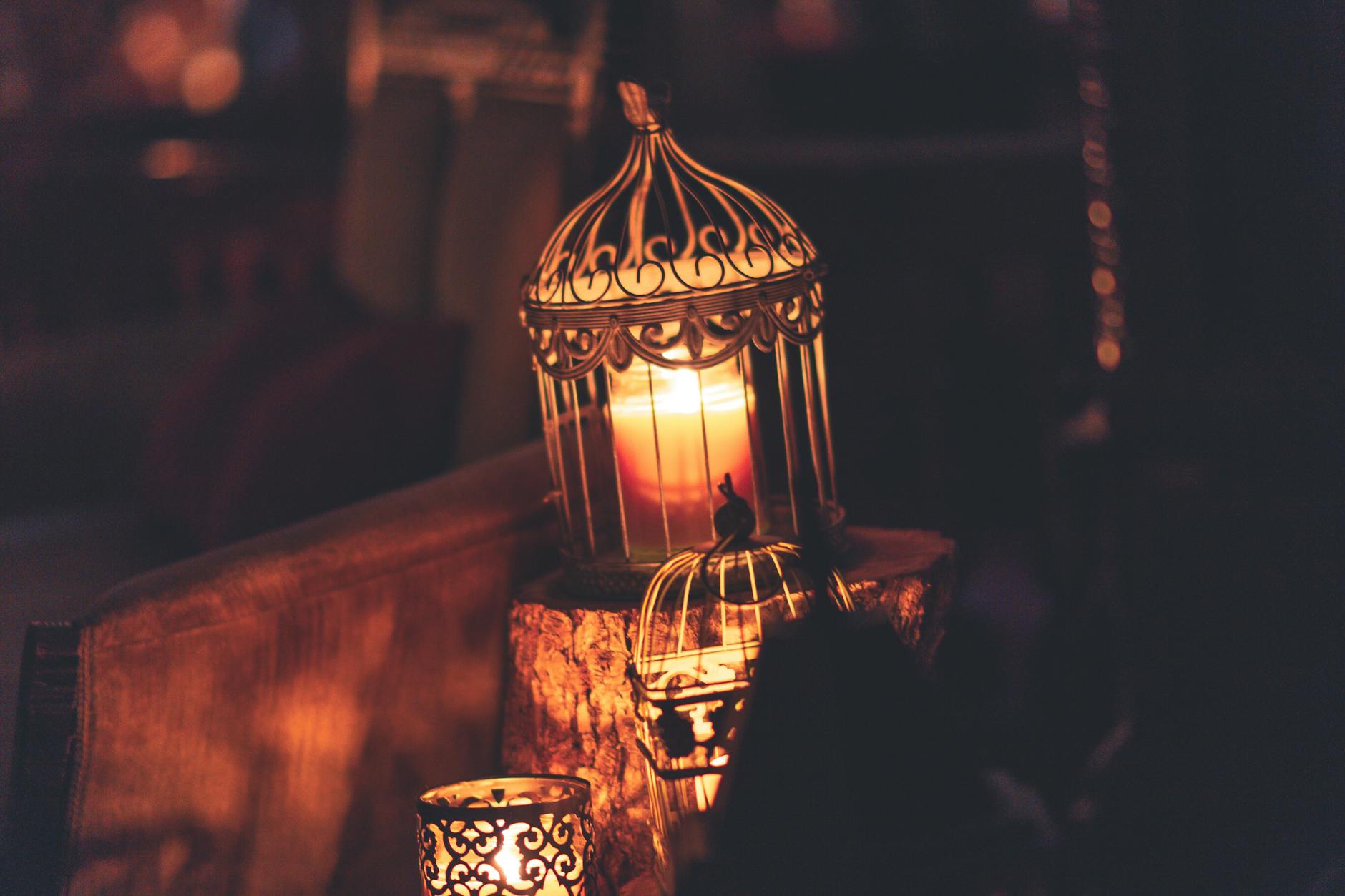 photo of brown metal cage with lighted candle