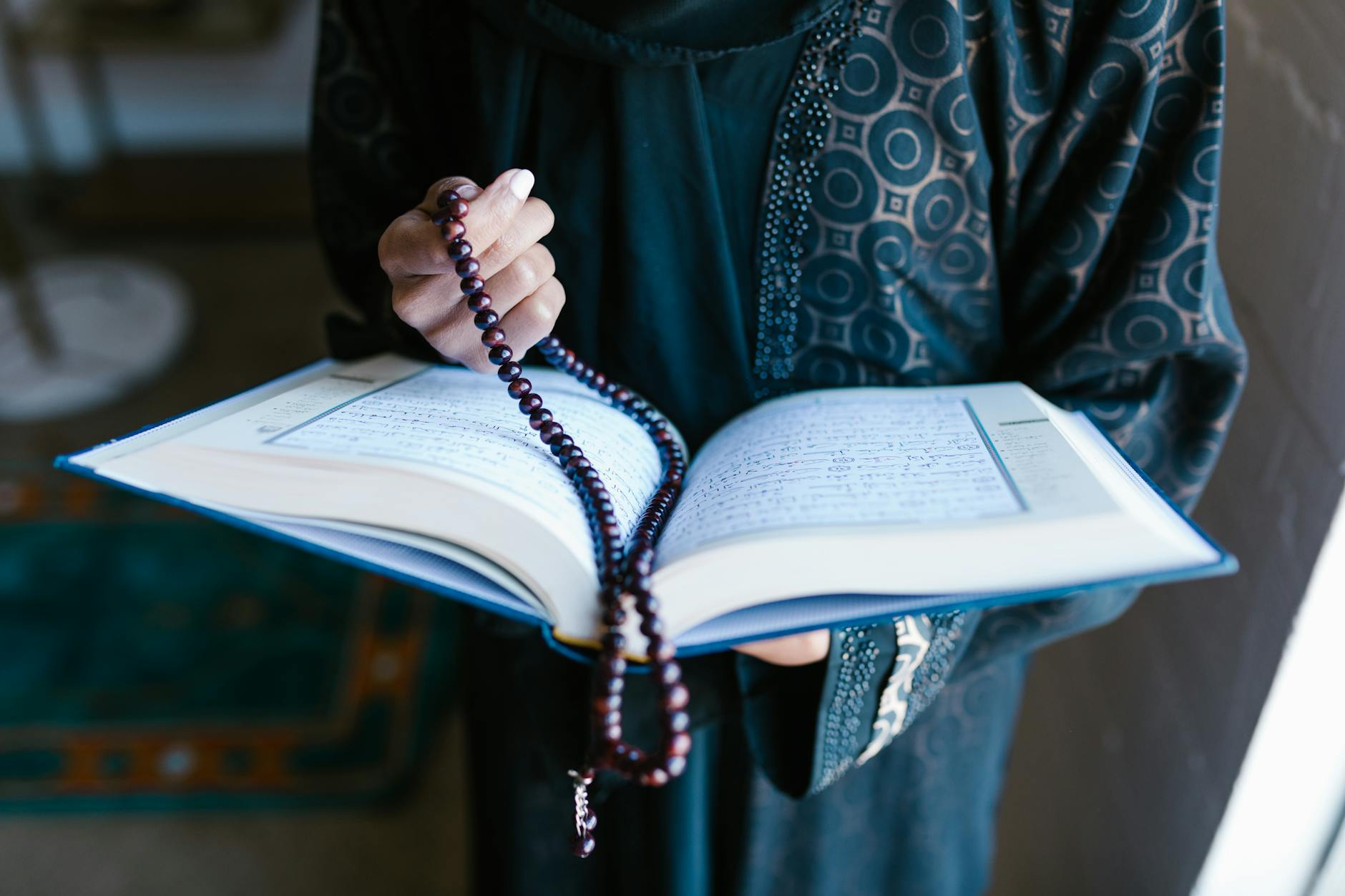 crop photo of woman holding a prayer beads and holy book