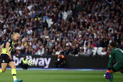 Manchester City’s Norwegian striker Erling Haaland (L) scores his third goal past West Ham United’s Polish goalkeeper Lukasz Fabianski at the London Stadium, in London on August 31, 2024. (Photo by HENRY NICHOLLS / AFP)