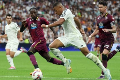 TOPSHOT – Real Madrid’s French forward #09 Kylian Mbappe (2R) is challenged by Real Valladolid’s French defender #06 Flavien Boyomo (2L) during the Spanish league football match between Real Madrid CF and Real Valladolid FC at the Santiago Bernabeu stadium in Madrid on August 25, 2024. (Photo by Pierre-Philippe MARCOU / AFP)