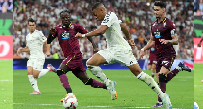 TOPSHOT – Real Madrid’s French forward #09 Kylian Mbappe (2R) is challenged by Real Valladolid’s French defender #06 Flavien Boyomo (2L) during the Spanish league football match between Real Madrid CF and Real Valladolid FC at the Santiago Bernabeu stadium in Madrid on August 25, 2024. (Photo by Pierre-Philippe MARCOU / AFP)