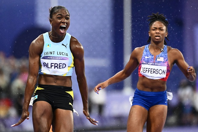 St Lucia’s Julien Alfred celebrates after winning ahead US’ Melissa Jefferson (R) the women’s 100m final of the athletics event at the Paris 2024 Olympic Games at Stade de France in Saint-Denis, north of Paris, on August 3, 2024. (Photo by Jewel SAMAD / AFP)