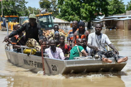 People affected by floods are escorted through flood water on a military boat in Maiduguri on September 12, 2024. (Photo by Audu MARTE / AFP)