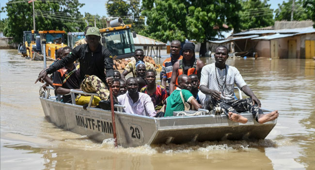 People affected by floods are escorted through flood water on a military boat in Maiduguri on September 12, 2024. (Photo by Audu MARTE / AFP)