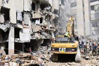 Workers use heavy construction equipment to remove debris from the site of an Israeli airstrike in Beirut, Lebanon, September 21, 2024 © Getty Images / Houssam Shbaro