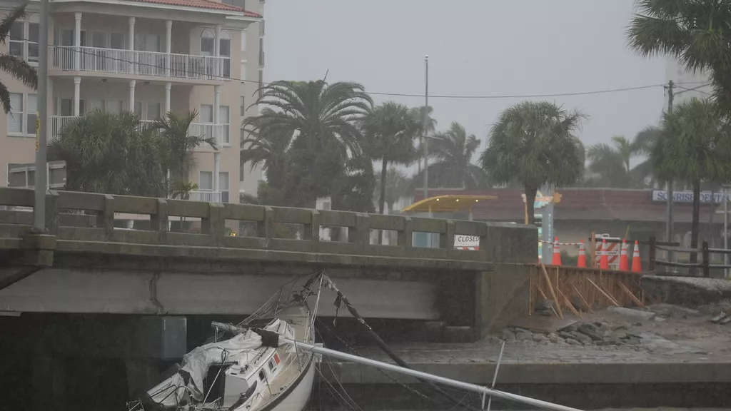 A boat damaged in Hurricane Helene rests against a bridge ahead of the arrival of Hurricane Milton, in South Pasadena, Fla.,