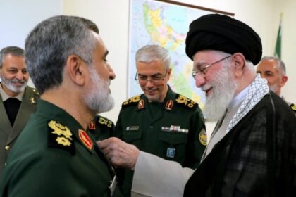 TOPSHOT – A handout picture provided by the office of Iran’s Supreme Leader Ayatollah Ali Khamenei on October 6, 2024 shows him (R)decorating the Islamic Revolutionary Guard Corps’ Aerospace Force Commander Brigadier General Amir Ali Hajizadeh (L) with the ‘Fath’ badge in Tehran for plannig the Iranian attack on Israel. (Photo by KHAMENEI.IR / AFP)