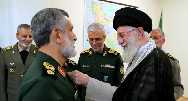 TOPSHOT – A handout picture provided by the office of Iran’s Supreme Leader Ayatollah Ali Khamenei on October 6, 2024 shows him (R)decorating the Islamic Revolutionary Guard Corps’ Aerospace Force Commander Brigadier General Amir Ali Hajizadeh (L) with the ‘Fath’ badge in Tehran for plannig the Iranian attack on Israel. (Photo by KHAMENEI.IR / AFP)