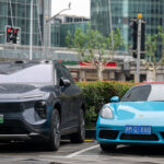 An electric car from the Chinese brand NIO and one from Porsche with a combustion engine are pictured during a visit by German Economy Minister Robert Habeck to China in June 2024. © Sebastian Christoph Gollnow/picture alliance via Getty Images