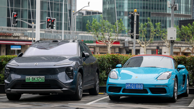 An electric car from the Chinese brand NIO and one from Porsche with a combustion engine are pictured during a visit by German Economy Minister Robert Habeck to China in June 2024. © Sebastian Christoph Gollnow/picture alliance via Getty Images