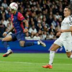 Barcelona’s Brazilian forward #11 Raphinha (L) scores his team’s fourth goal during the Spanish league football match between Real Madrid CF and FC Barcelona at the Santiago Bernabeu stadium in Madrid on October 26, 2024. (Photo by OSCAR DEL POZO / AFP)