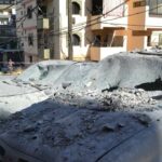 Damaged cars lie in a cordoned-off area hit in an Israeli airstrike that targeted an apartment building in the Palestinian refugees camp of Al-Baddawi near the northern Lebanese city of Tripoli on October 5, 2024. – Palestinian militant group Hamas said an Israeli strike killed one of its commanders, Saeed Attallah Ali, his wife and two daughters, in the refugee camp on October 5, the first time the area had been hit since the start of the Gaza war. (Photo by FATHI AL MASRI / AFP)