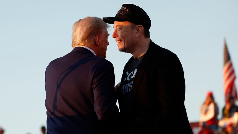 Donald Trump (L) embraces Elon Musk during a campaign rally in Butler, Pennsylvania, October 5, 2024 © Getty Images / Anna Moneymaker