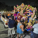 Artisans at a workshop carry a mud idol of the Hindu goddess Durga to load it on to a vehicle during the Durga Puja festival in Guwahati, India,