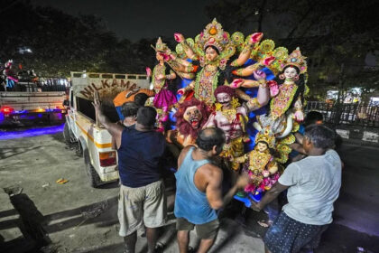 Artisans at a workshop carry a mud idol of the Hindu goddess Durga to load it on to a vehicle during the Durga Puja festival in Guwahati, India,