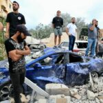 People inspect the damage at the site of an Israeli airstrike that targeted an apartment building in town of Barja south of Beirut on October 12, 2024. (Photo by Mahmoud ZAYYAT / AFP)