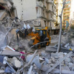 Rescue workers use a bulldozer to remove rubble of destroyed buildings at the site of an Israeli airstrike in Beirut's southern suburb, Lebanon, October 21, 2024 © AP / Hassan Ammar