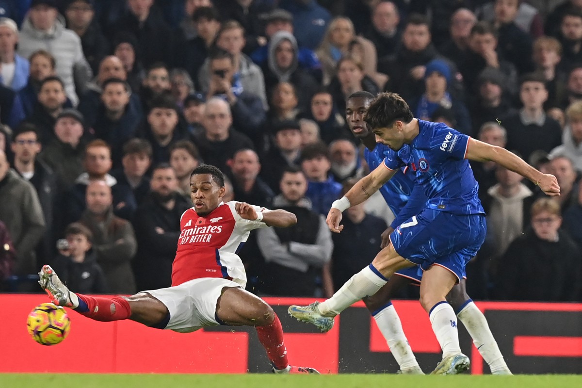 Chelsea’s Portuguese midfielder #07 Pedro Neto (R) shoots to score their first goal during the English Premier League football match between Chelsea and Arsenal at Stamford Bridge in London on November 10, 2024. (Photo by Glyn KIRK / AFP) /