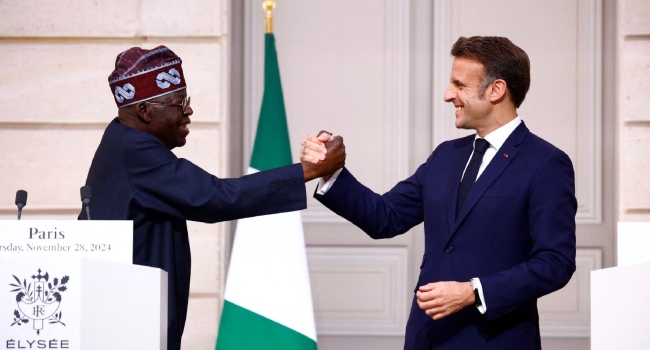 French President Emmanuel Macron (R) and Nigerian president Bola Tinubu shake hands as they arrive to give a press conference following a meeting at the Elysee palace in Paris, on November 28, 2024. (Photo by Sarah Meyssonnier / POOL / AFP)