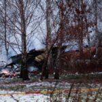 A Lithuanian medic takes a photo on his mobile phone of the wreckage of a cargo plane following its crash near the Vilnius International Airport in Vilnius on November 25, 2024. – A DHL cargo plane flying from Germany to Lithuania crashed early on November 25, 2024 near the airport of the capital Vilnius killing one person, firefighters said. (Photo by Petras Malukas / AFP)