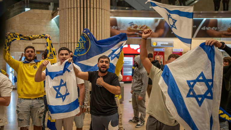 Maccabi Tel Aviv fans cheer as they arrive at Ben Gurion airport on a flight from Amsterdam on November 8, 2024 © Picture alliance / Getty Images