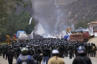 Police officers advance towards supporters of former President Evo Morales, who are blocking a road near Parotani, Bolivia on November 1, 2024. © Pablo Rivera / Anadolu / Getty Images