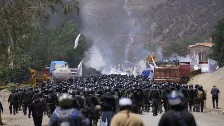 Police officers advance towards supporters of former President Evo Morales, who are blocking a road near Parotani, Bolivia on November 1, 2024. © Pablo Rivera / Anadolu / Getty Images