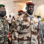 In this file photograph taken on September 17, 2021, President of the National Committee for Rally and Development (CNRD) Colonel Mamady Doumbouya (C) leaves a meeting with high level representatives of the Economic Community of West African States (ECOWAS) in Conakry. JOHN WESSELS / AFP