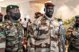 In this file photograph taken on September 17, 2021, President of the National Committee for Rally and Development (CNRD) Colonel Mamady Doumbouya (C) leaves a meeting with high level representatives of the Economic Community of West African States (ECOWAS) in Conakry. JOHN WESSELS / AFP