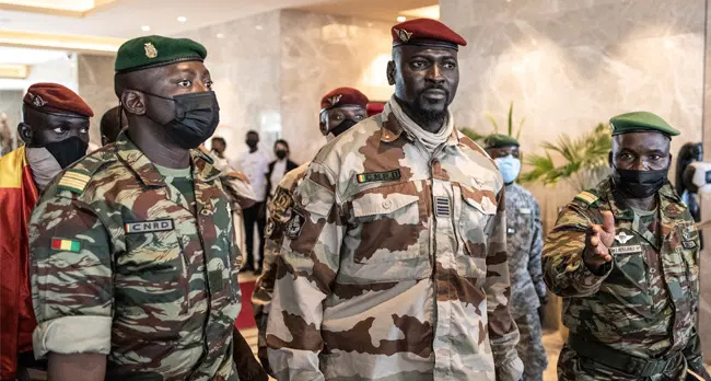 In this file photograph taken on September 17, 2021, President of the National Committee for Rally and Development (CNRD) Colonel Mamady Doumbouya (C) leaves a meeting with high level representatives of the Economic Community of West African States (ECOWAS) in Conakry. JOHN WESSELS / AFP