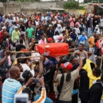 Protesters in Maputo carry a mock coffin with the face of Frelimo's Daniel Chapo, who is to succeed President Filipe Nyusi [Siphiwe Sibeko/Reuters]