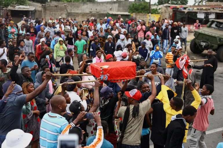 Protesters in Maputo carry a mock coffin with the face of Frelimo's Daniel Chapo, who is to succeed President Filipe Nyusi [Siphiwe Sibeko/Reuters]