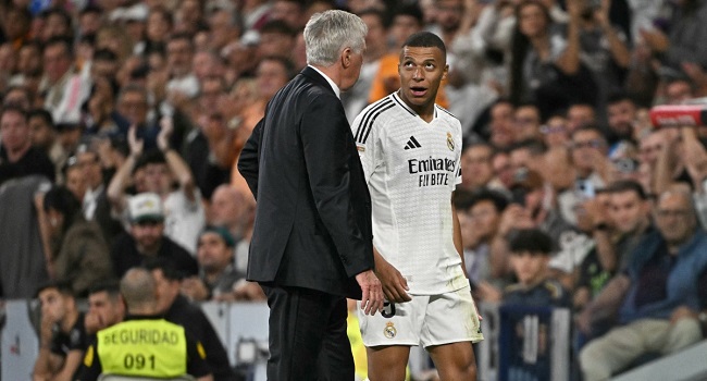 Real Madrid’s French forward #09 Kylian Mbappe talks with Real Madrid’s Italian coach Carlo Ancelotti as he leaves the pitch during the Spanish league football match between Real Madrid CF and Deportivo Alaves at the Santiago Bernabeu stadium in Madrid on September 24, 2024. (Photo by Javier SORIANO / AFP)