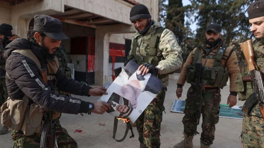 AFP: Rebels burning pictures of the Syrian president in Zarbah on the outskirts of Aleppo on Wednesday