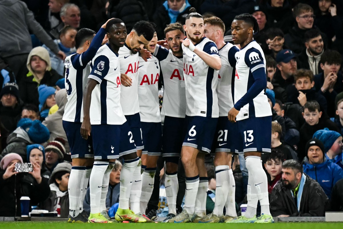 Tottenham Hotspur’s English midfielder #10 James Maddison (C) celebrates with teammates after scoring his team second goal during the English Premier League football match between Manchester City and Tottenham Hotspur at the Etihad Stadium in Manchester, north west England, on November 23, 2024. (Photo by Paul ELLIS / AFP)