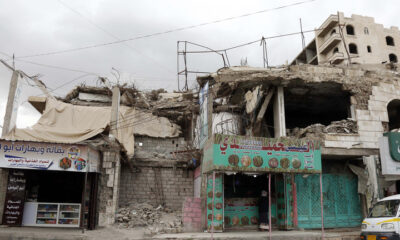 FILE PHOTO: A man buys from a shop located in a building destroyed in past aerial strikes in Sana'a, Yemen. © Mohammed Hamoud / Getty Images