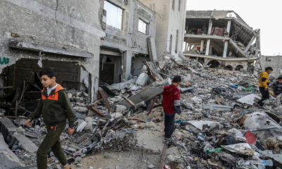 Children walk past destroyed buildings in Khan Yunis, Gaza on December 10, 2024. © Abed Rahim Khatib / Anadolu / Getty Images