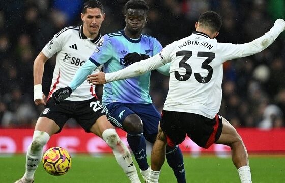 Fulham’s English-born US defender #33 Antonee Robinson (R) vies with Arsenal’s English midfielder #07 Bukayo Saka (C) during the English Premier League football match between Fulham and Arsenal at Craven Cottage in London on December 8, 2024. (Photo by JUSTIN TALLIS / AFP)