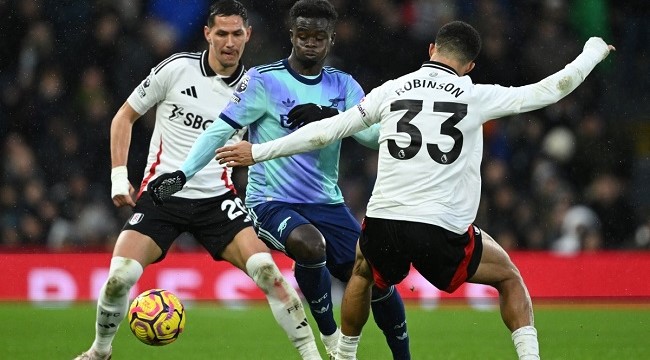 Fulham’s English-born US defender #33 Antonee Robinson (R) vies with Arsenal’s English midfielder #07 Bukayo Saka (C) during the English Premier League football match between Fulham and Arsenal at Craven Cottage in London on December 8, 2024. (Photo by JUSTIN TALLIS / AFP)