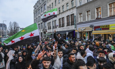 Expatriate Syrians gather with flags to celebrate the fall of the Assad regime in Syria on December 8, 2024 in Berlin, Germany. © Omer Messinger / Getty Images