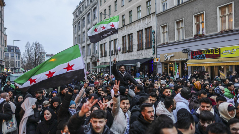 Expatriate Syrians gather with flags to celebrate the fall of the Assad regime in Syria on December 8, 2024 in Berlin, Germany. © Omer Messinger / Getty Images