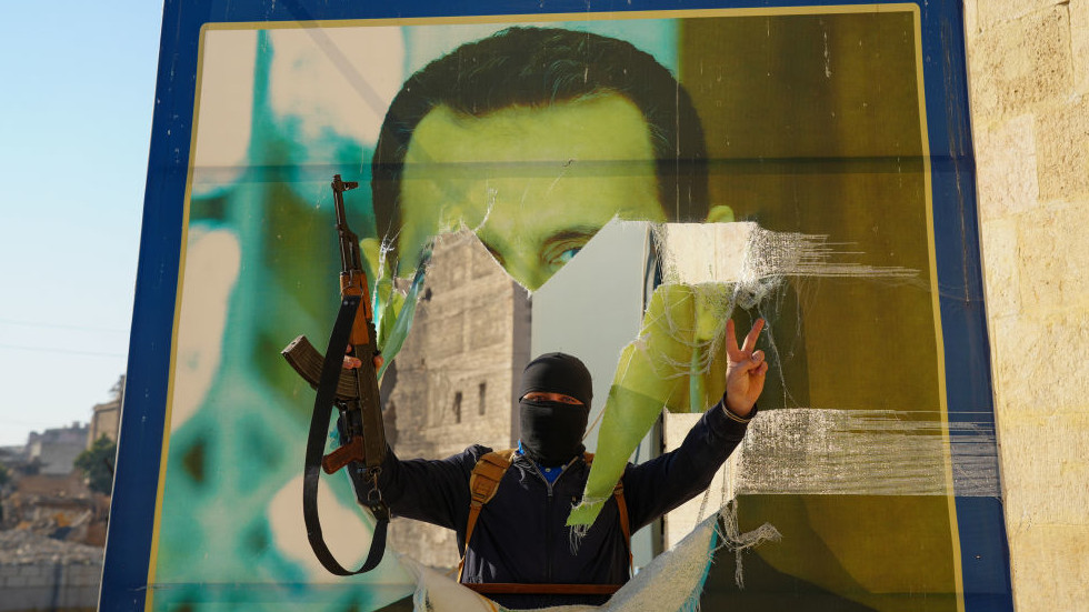 Jihadist militant tearing down a poster of Syrian Presdient Bashar Assad in Aleppo, Syria, November 30, 2024. © Getty Images / Rami Alsayed/NurPhoto