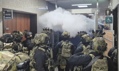 National Assembly employees spray a fire extinguisher towards soldiers at the National Assembly in Seoul, Dec. 4, 2024. © Cho Da-un / Yonhap via AP