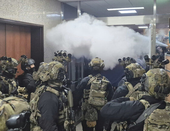 National Assembly employees spray a fire extinguisher towards soldiers at the National Assembly in Seoul, Dec. 4, 2024. © Cho Da-un / Yonhap via AP