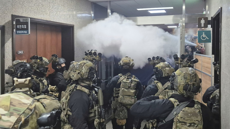 National Assembly employees spray a fire extinguisher towards soldiers at the National Assembly in Seoul, Dec. 4, 2024. © Cho Da-un / Yonhap via AP