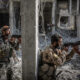 FILE PHOTO. Two armed soldiers of the Syrian Democratic Forces (SDF) standing next to a column of a destroyed building while battles against the Islamic State (IS) terror militia continue in Raqqa, Syria. © Morukc Umnaber/Getty Images