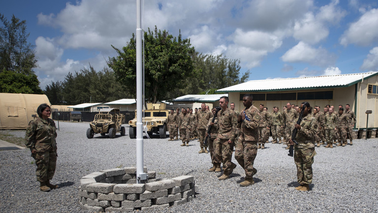 FILEPHOTO. In this Aug. 26, 2019 file photo released by the U.S. Air Force, airmen from the 475th Expeditionary Air Base Squadron conduct a flag-raising ceremony, signifying the change from tactical to enduring operations, at Camp Simba, Manda Bay, Kenya. © Staff Sgt. Lexie West/U.S. Air Force via AP