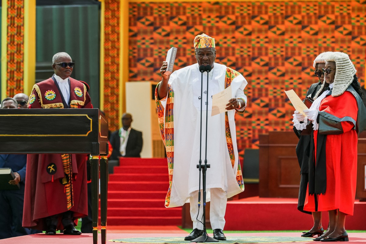 Ghana’s new President John Mahama (C) holds a Bible as he takes oath of office at his inauguration at the Independence Square in Accra on January 7, 2025.(Photo by Nipah Dennis / AFP)