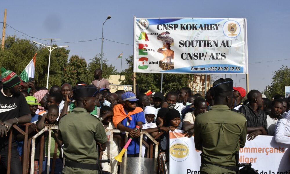 People carry a sign in support of the Alliance of Sahel States (AES) during a gathering to celebrate the withdrawal of Mali, Niger and Burkina Faso from the Economic Community of West African States (ECOWAS) in Niamey on January 28, 2025. Photo by Boureima Hama / AFP)